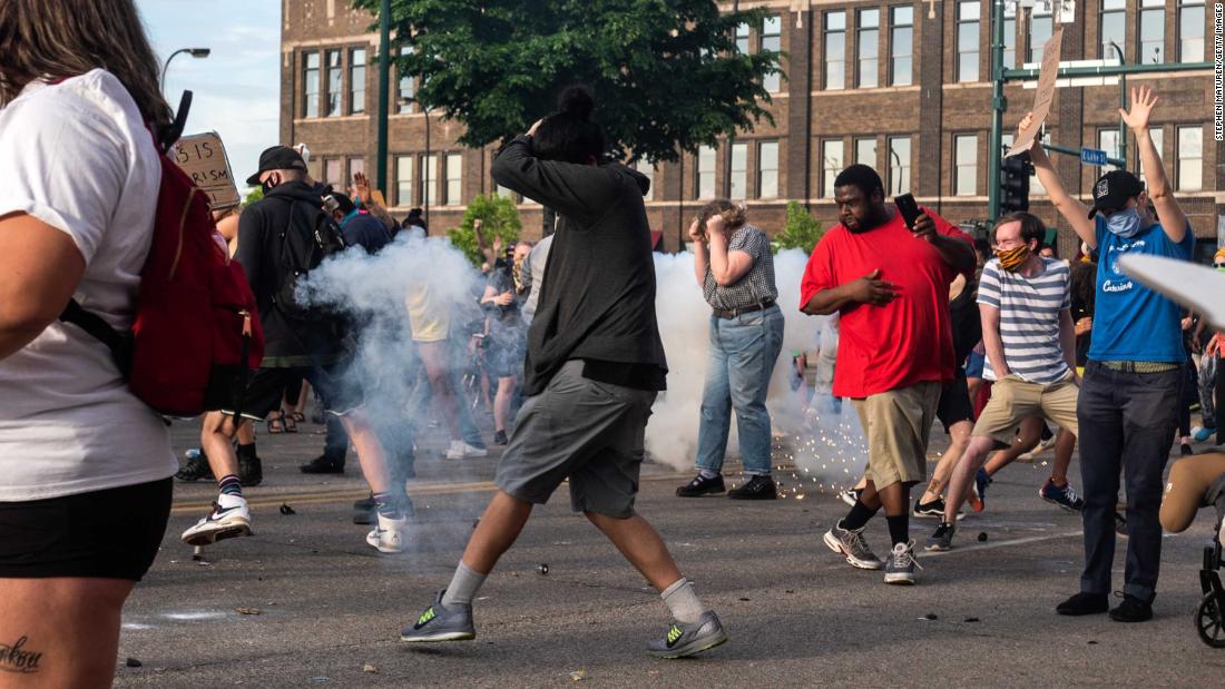 Minneapolis protesters react as a projectile launched by police explodes near them on May 27.
