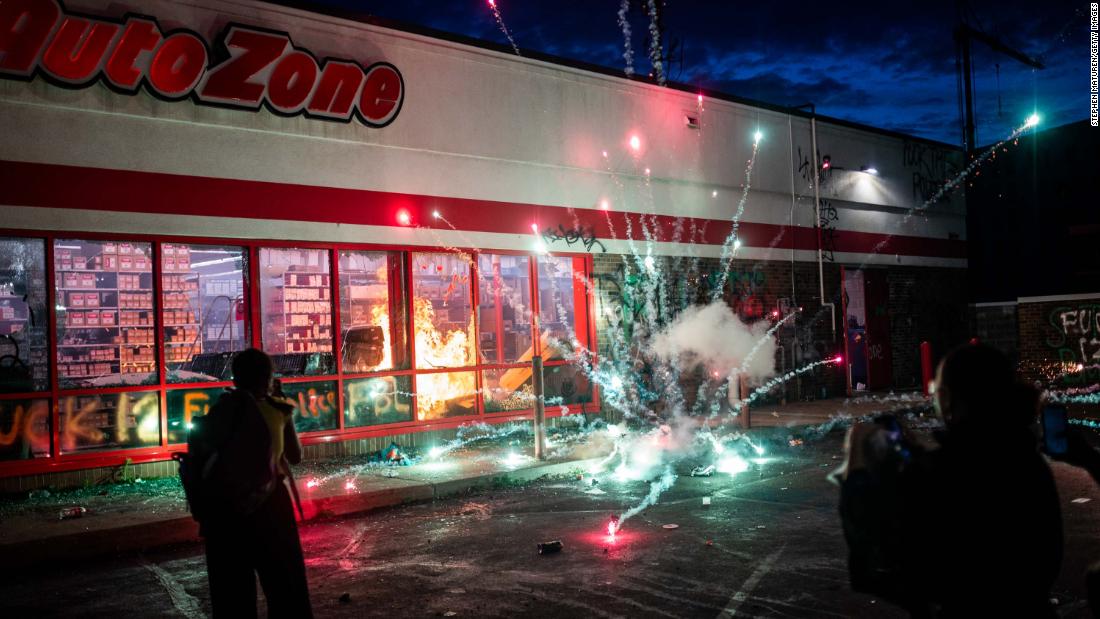 A firework explodes as a fire burns inside an Auto Zone store in Minneapolis on May 27.
