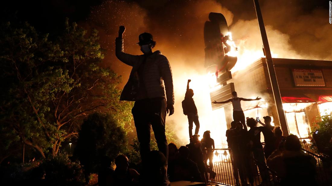 Protesters gather in front of a burning fast-food restaurant in Minneapolis on May 29.