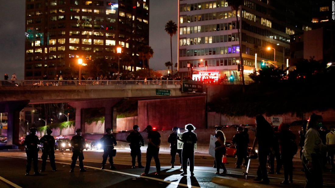 Protesters confront police officers while blocking the 110 Freeway in Los Angeles on May 29. 