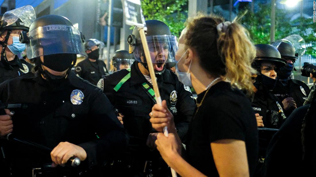 Police officers move forward to clear a street during a protest in downtown Los Angeles on May 29.