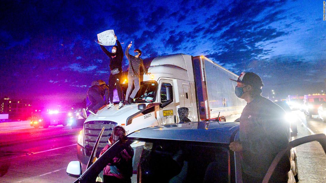 Demonstrators in Oakland climb atop a truck while blocking all lanes of traffic on Interstate 880 在5月 29.