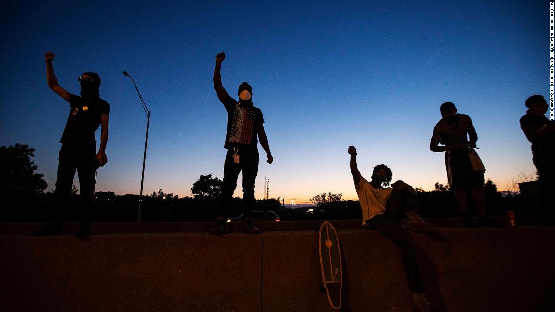 Men raise their fists after making their way onto Interstate 75 and stopping traffic in Cincinnati on May 29.