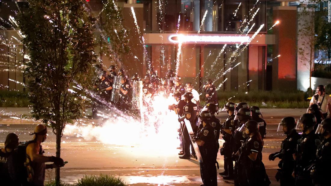 A firework explodes by a police line near the White House on May 30.