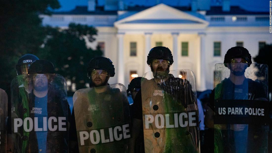 Police stand guard outside the White House as people gather to protest on May 31.