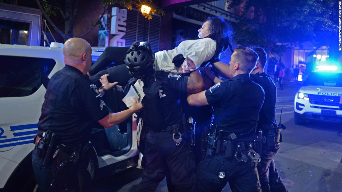 A woman is carried by police in Charlotte, Noord-Carolina, op Mei 31.