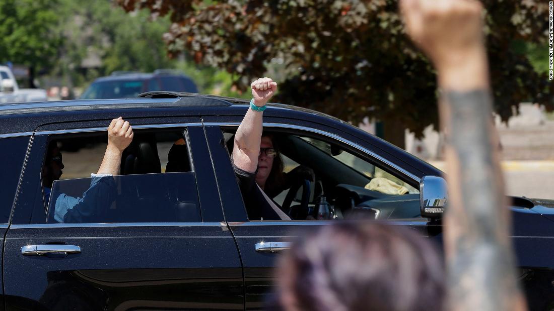 Passengers hold up their fists in solidarity with protesters as they drive by the Wood County Courthouse in Wisconsin Rapids, 威斯康星州, 在六月 2.
