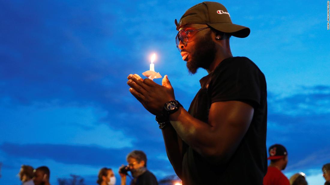 A man in Minneapolis holds a candle June 3 near the scene of George Floyd&#39;se dood.