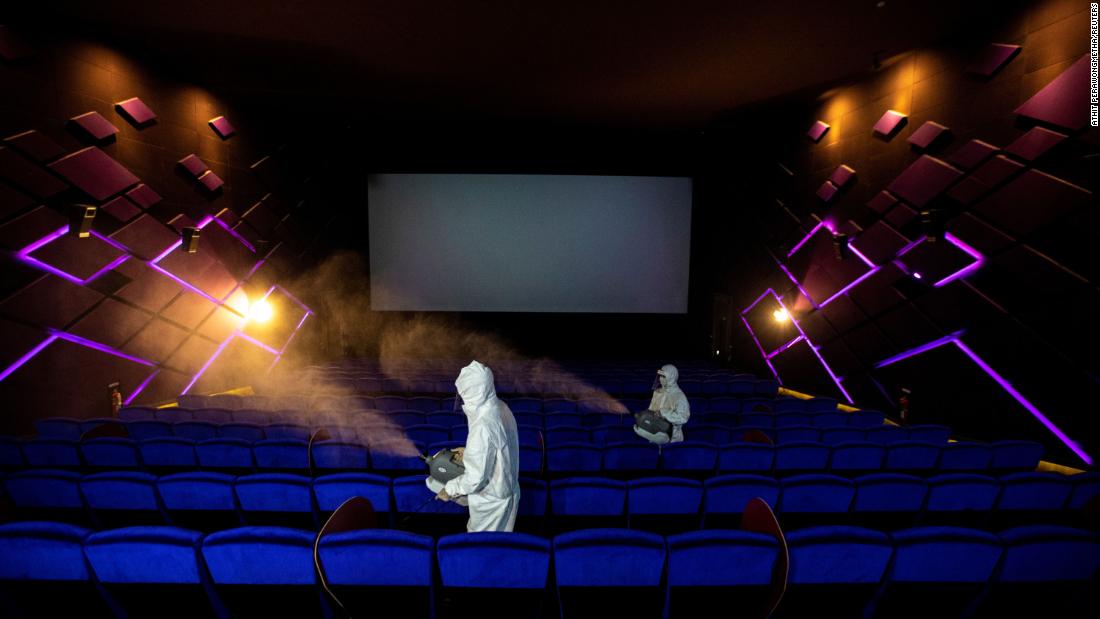 Workers spray disinfectant inside a movie theater in Bangkok, 泰国, ahead of its reopening on May 31. 