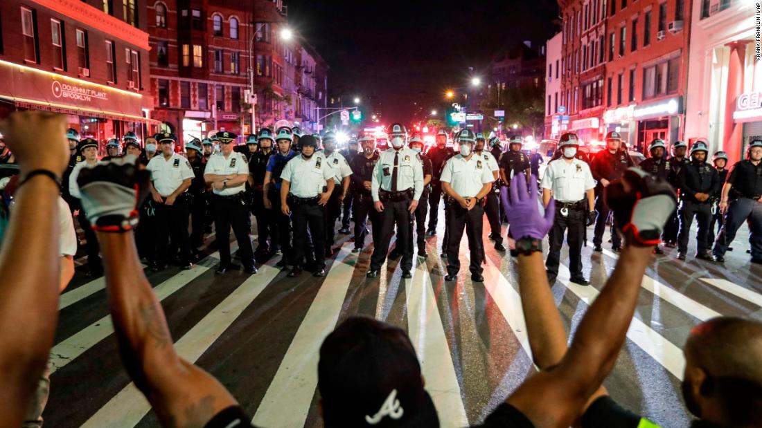 Protesters take a knee in front of a line of police officers in Brooklyn, 뉴욕, 6 월 4.