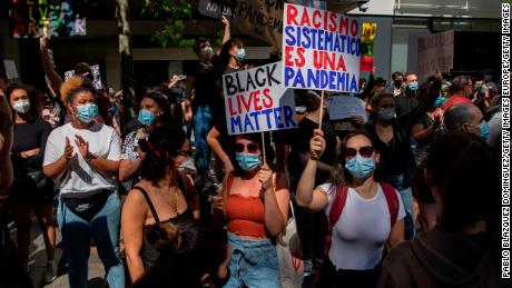 En Madrid, un manifestante advierte que "El racismo sistémico es una pandemia." 