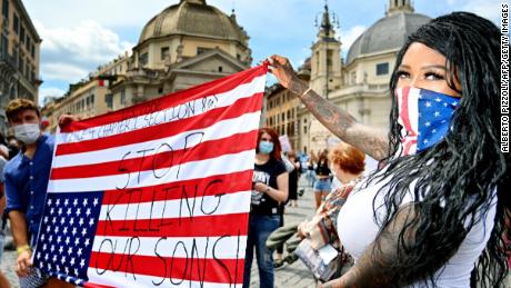 Los manifestantes sostienen una bandera estadounidense al revés en Roma.