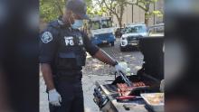 A Camden County officer grills hot dogs for one of the department's pop-up neighborhood parties.