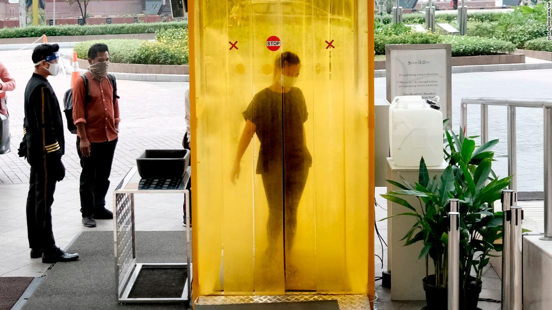 A woman is sprayed with disinfectant before entering a shopping mall in Jakarta, インドネシア, 6月に 9.