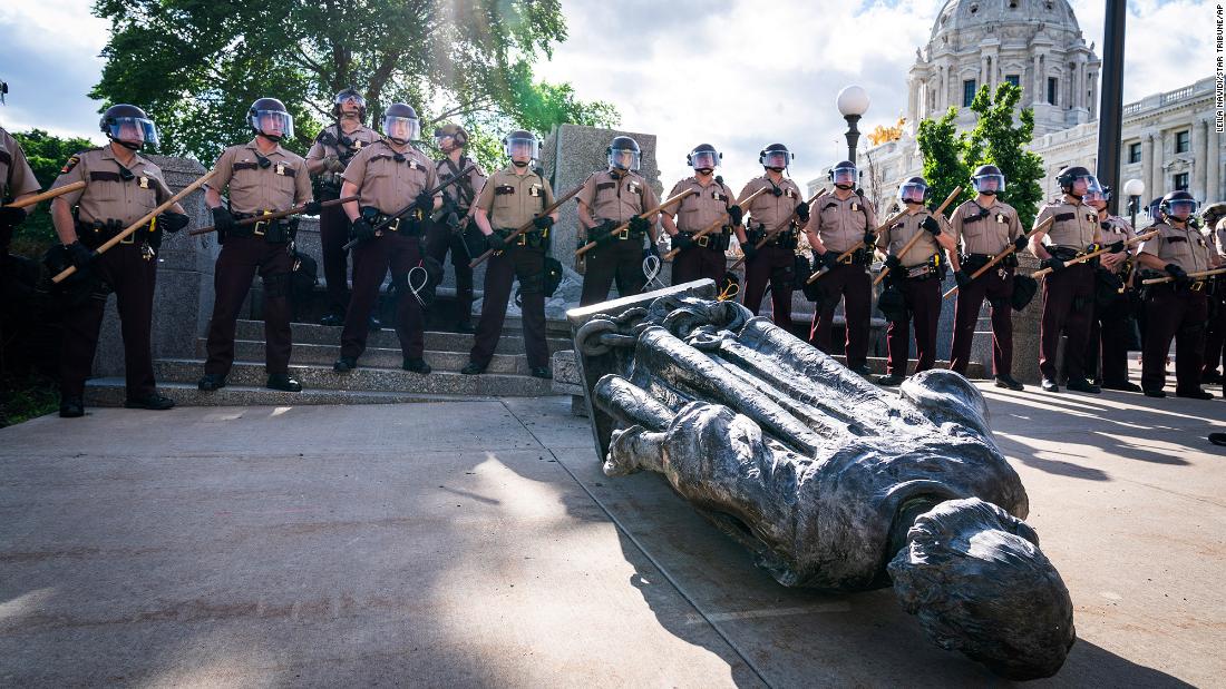Minnesota state troopers surround a statue of Christopher Columbus after activists pulled it down in front of the Capitol in St. Paul on June 10. &lt;a href =&quot;https://www.cnn.com/2020/06/10/us/christopher-columbus-statues-down-trnd/index.html&quot; teiken =&quot;_ leeg&ampkwotasiet;&gt;Columbus has long been a contentious figure in historltamp;lt;/a&gt; for his treatment of the Indigenous communities he encountered and for his role in the violent colonization at their expense. 