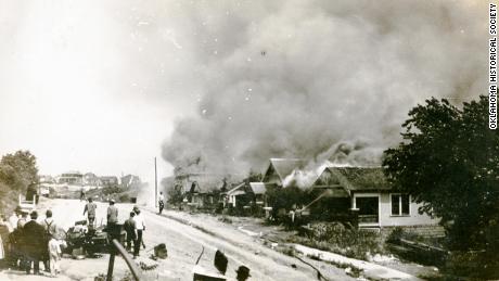 A group of people looking at smoke in the distance coming from damaged properties following the Tulsa Race Massacre, Tulsa, Oklahoma, June 1921. 