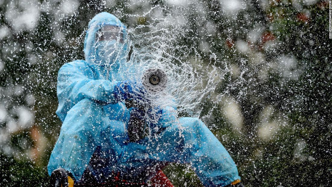 A firefighter in Chennai, 印度, sprays disinfectant to help prevent the spread of the coronavirus on June 11.