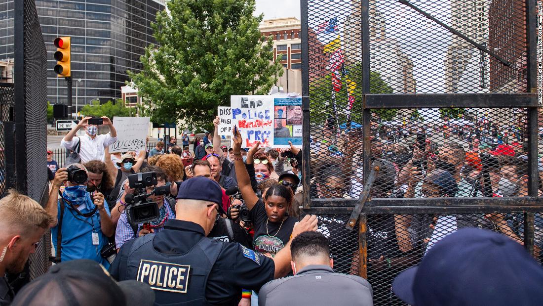 Protesters try to enter a gate leading to the BOK Center, where President Donald Trump &lt;a href =&quot;http://www.cnn.com/2020/06/20/politics/gallery/trump-rally-tulsa/index.html&quot; teiken =&quot;_ leeg&ampkwotasiet;&gt;was holding a rallltamp;lt;/a&gt; in Tulsa, Oklahoma, op Junie 20. It was the President&#39;s first rally since the coronavirus pandemic began.