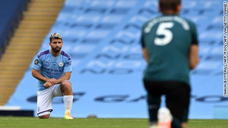 Manchester City striker Sergio Aguero(L) and Burnley defender James Tarkowski take a knee in support of the Black Lives Matter movement.