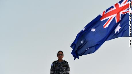 A Royal Australian Navy personnel stands next to the Australia&#39;s national flag as she takes part in training exercise in the Sri Lankan capital Colombo on March 26, 2019.