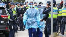 Medical staff wearing PPE walk into the Flemington public housing flats on July 5 in Melbourne, Australia after nine public housing estates were locked down.