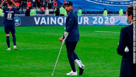 Paris Saint-Germain forward Kylian Mbappe walks with crutches after winning the French Cup final.