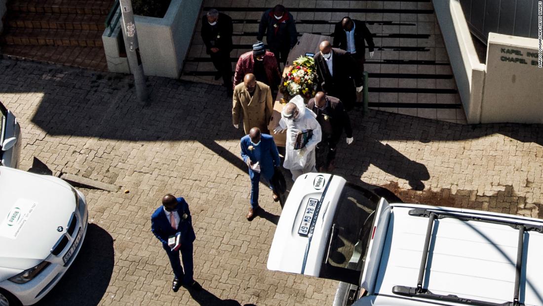 The casket of a coronavirus victim is carried from a funeral home in Johannesburg on July 26.