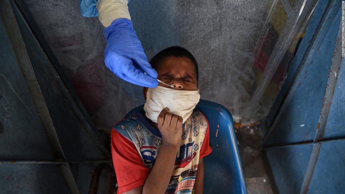 A health worker tests a child for Covid-19 at a school in New Delhi on July 27.
