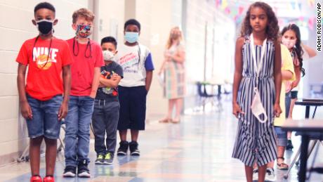 Corinth Elementary School students social distance as they line up after leaving the restroom on their first day back to school Monday, July 27, 2020 in Corinth, Mississippi. (Adam Robison/The Northeast Mississippi Daily Journal via AP)