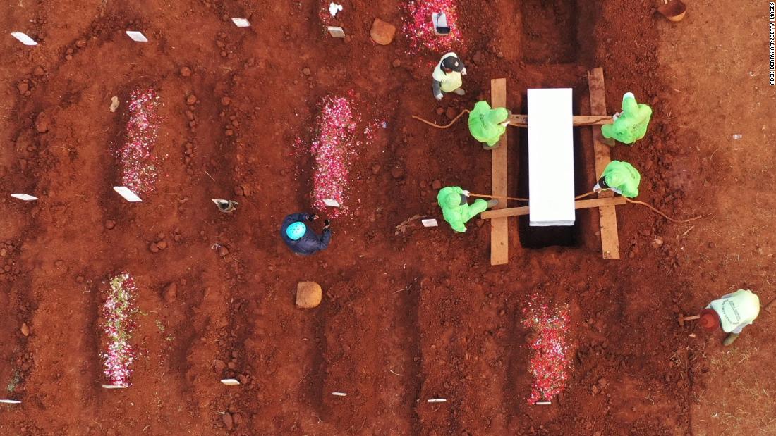 Gravediggers bury a coronavirus victim at the Pondok Ranggon cemetery in Jakarta, 印度尼西亚, 在八月 10.