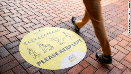 A pedestrian walks past a social distancing sign on August 14, 2021 in Wellington, New Zealand.