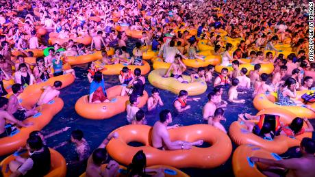 This photo taken on August 15, 2021 shows people watching a performance as they cool off in a swimming pool in Wuhan in China's central Hubei province. 