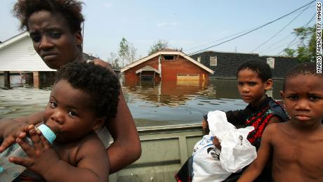 A mother and her children are rescued by boat from New Orleans&#39; Lower Ninth Ward in the aftermath of Hurricane Katrina.