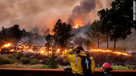 A firefighter rubs his head while watching the LNU Lightning Complex fires spread through the Berryessa Estates neighborhood of unincorporated Napa County, California, on Friday, August 21.