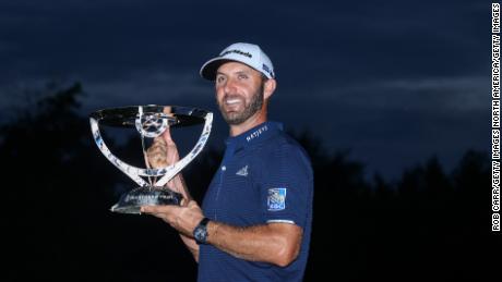 Johnson celebrates with the trophy after winning The Northern Trust.