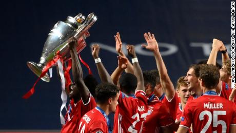 Alphonso Davies holds the Champions League the trophy aloft after beating PSG.