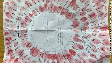 A petition signed by residents with their fingerprints in red ink stamped over signatures.
