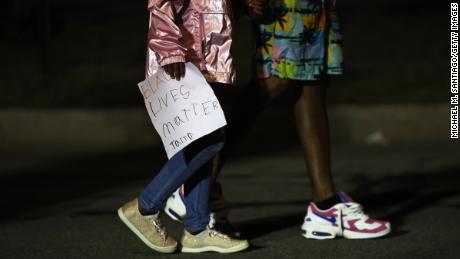 A child walks with a homemade sign in front of the Public Safety building after marching for Daniel Prude on September 06, 2020 in Rochester, New York.