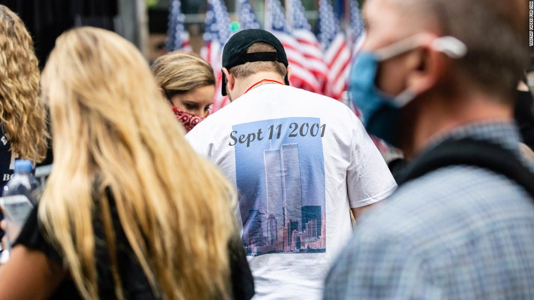The World Trade Center towers are seen on a man&#39;s T-shirt in the crowd.