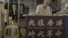 Lam Wing-kee in his Taipei book shop, where a banner displays slogans which have been declared subversive in Hong Kong.