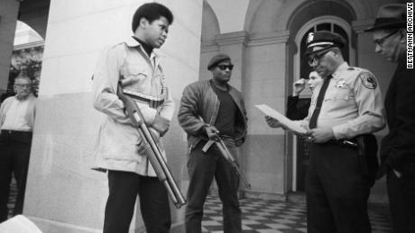Two members of the Black Panther Party are met on the steps of the State Capitol in Sacramento, California, on May 2, 1967. Police Lt. Ernest Holloway informed them they would be allowed to keep their weapons as long as they caused no trouble.