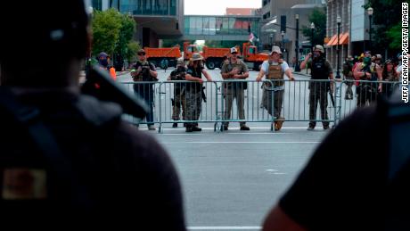 Supporters of the NFAC, an all-Black armed group, face off against the Three Percenters, an armed far-right group -- separated by police barricades -- at a protest against the killing of Breonna Taylor in Louisville, Kentucky, on July 25. 