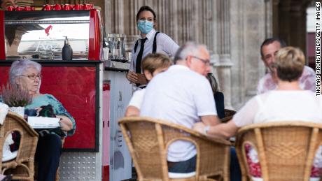 A waitress in Vienna wears a face mask as required by the new, stricter rules put in place by the Austrian government on September 14.