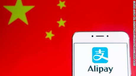 HONGKONG - 06.04.2019: In dieser Fotoabbildung ist eine chinesische Online-Zahlungsplattform der Alibaba Group, Alipay, auf einem Android-Mobilgerät mit der Flagge der Volksrepublik China im Hintergrund zu sehen. (Fotoillustration von Budrul Chukrut / SOPA Images / LightRocket über Getty Images)