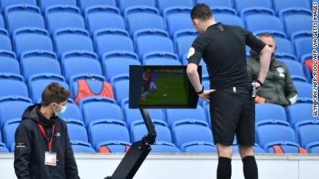 Referee Chris Kavanagh checks the VAR screen during the match between Brighton and Manchester United. 