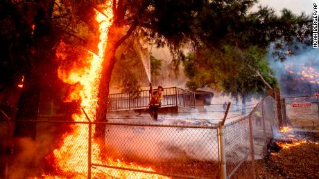 Cal Fire Capt. Jesse Campbell works to save the Louis Stralla Water Treatment Plant as the Glass Fire burns in St. 헬레나.