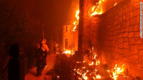Firefighters walk through the burning Chateau Boswell Winery as the Glass Fire moves through the area on September 27, 2020 in St. Helena, California.