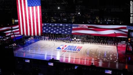 Los Angeles Lakers and Miami Heat players pause for the national anthem prior to the first half of Game 1 of basketball&#39;s NBA Finals Wednesday, Sept. 30, 2020, in Lake Buena Vista, Fla. (AP Photo/Mark J. Terrill)