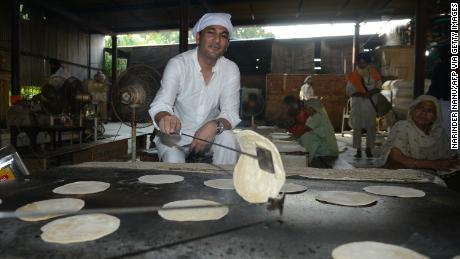 Vikas Khanna, MasterChef India host and executive chef of Junoon restaurant in New York, prepares a  chappati (flat bread) for a communal vegetarian meal at the Sikh Shrine Golden temple in Amritsar on September 7, 2016.  