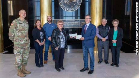 Gov. Doug Burgum presents Ronald Hepper&#39;s dog tag to his wife Ruth. They were joined by (from left) Maj. Gen. Al Dohrmann, Hepper&#39;s daughter Julie Hornbacher and her husband, Jim, and Ron Hepper&#39;s brother Stanley Hepper and his wife, Kathleen.